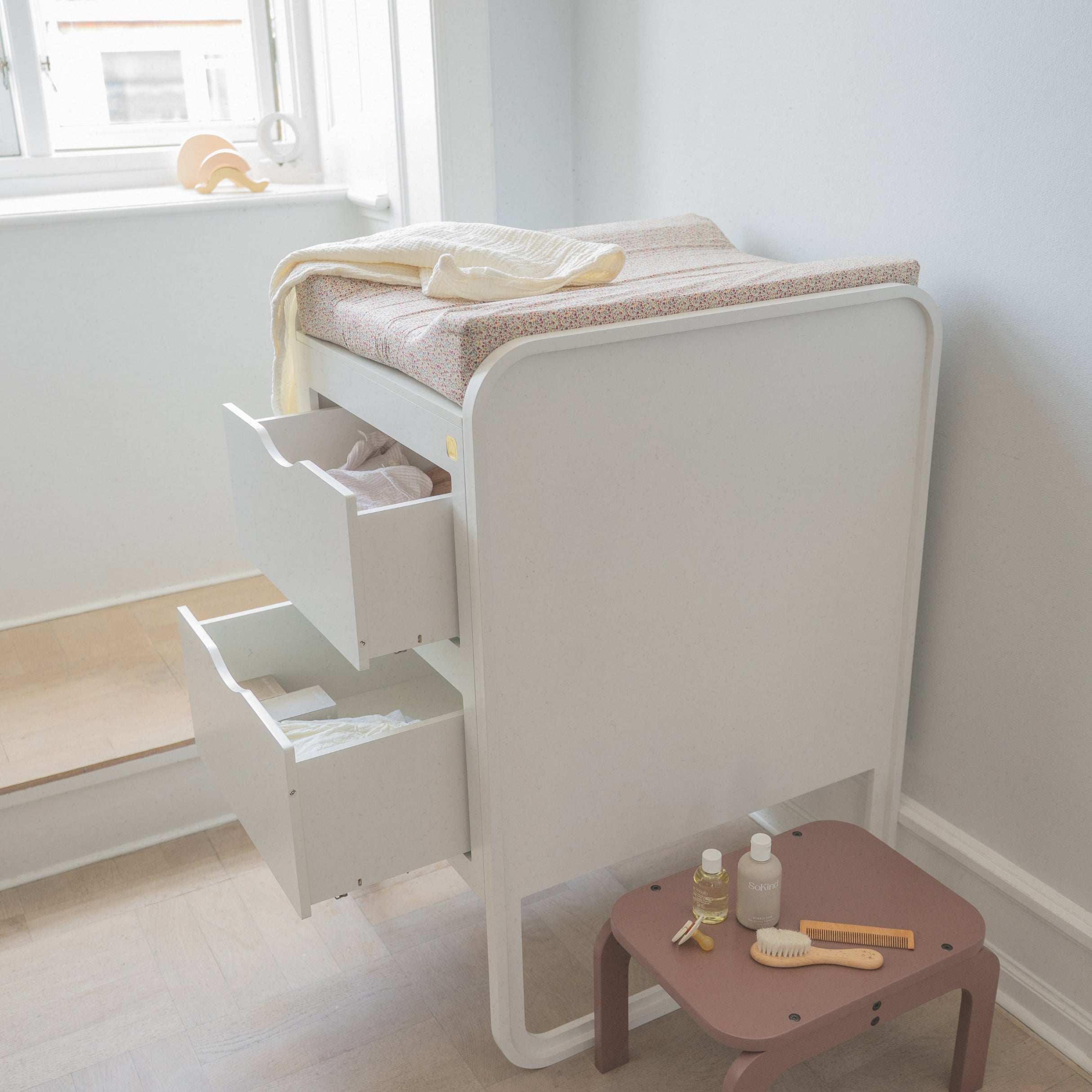White changing table with drawers in a minimalistic room