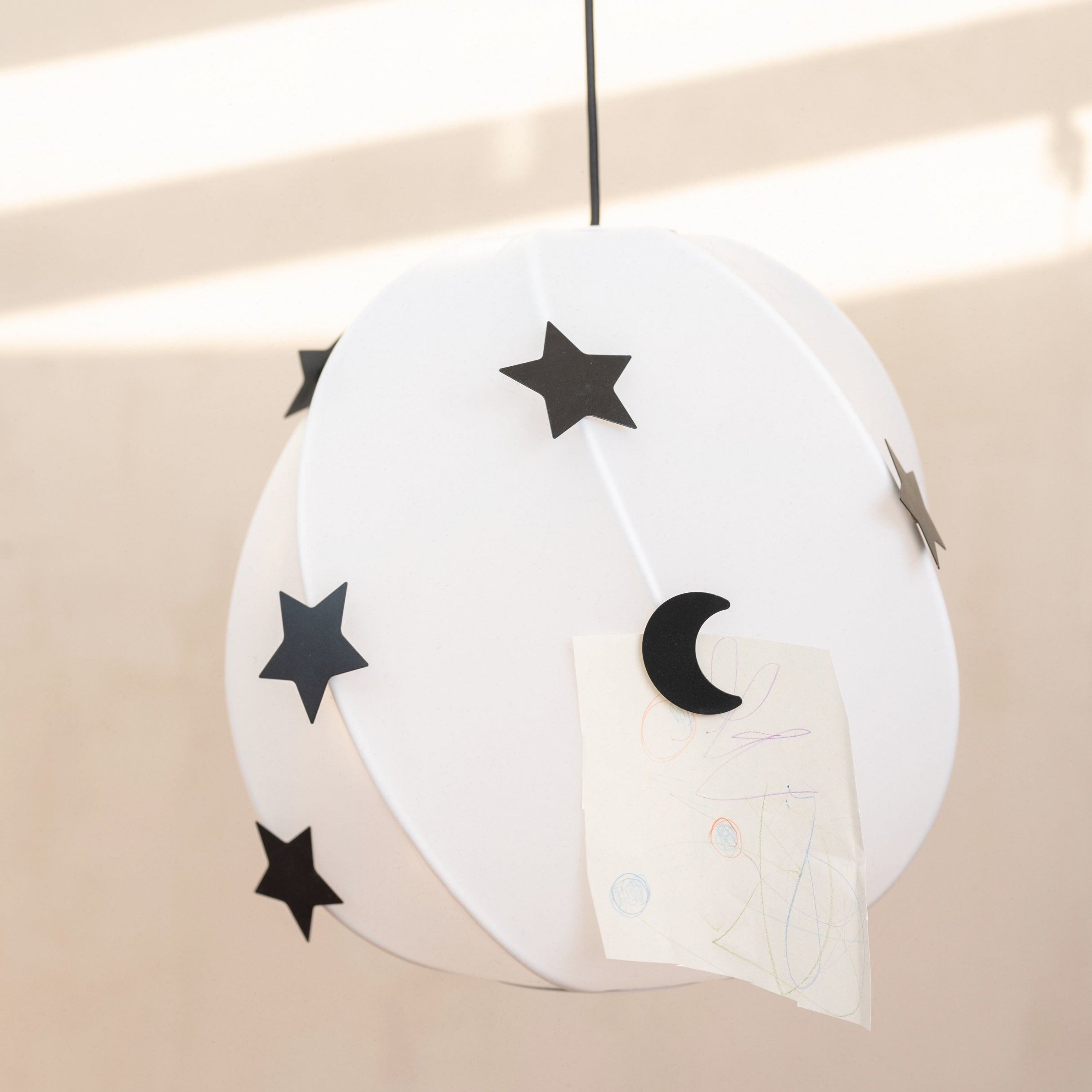 Decorative hanging with black stars and moon on a beige background