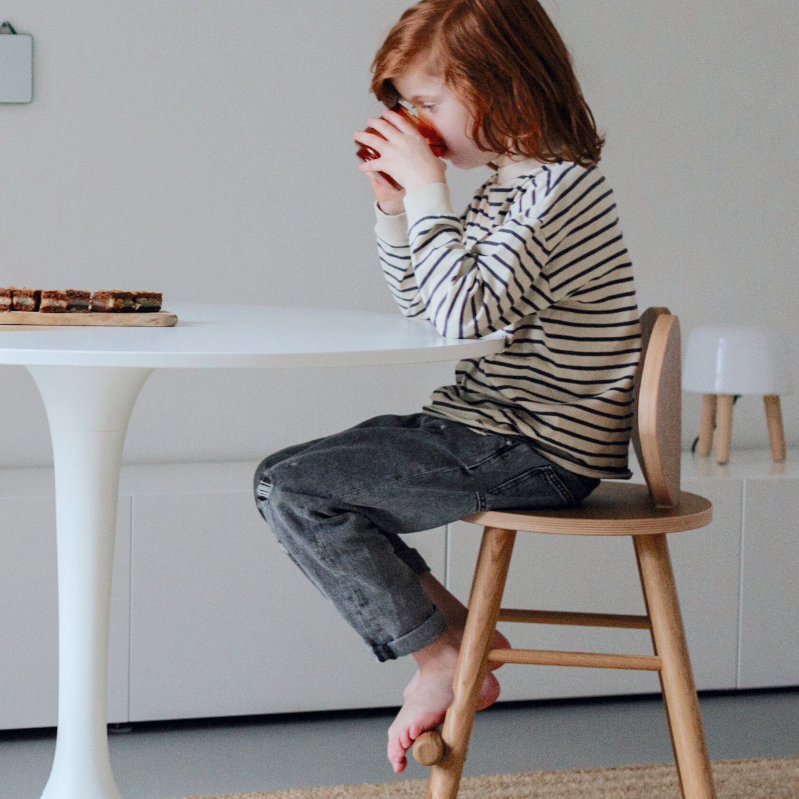 A child sitting on Nofred Oak Mouse Chair Junior