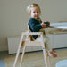 Baby girl sitting at table in high chair
