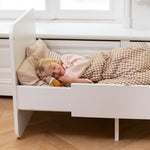 Nofred Baby & Jr. Bed White with a girl sleeping in it