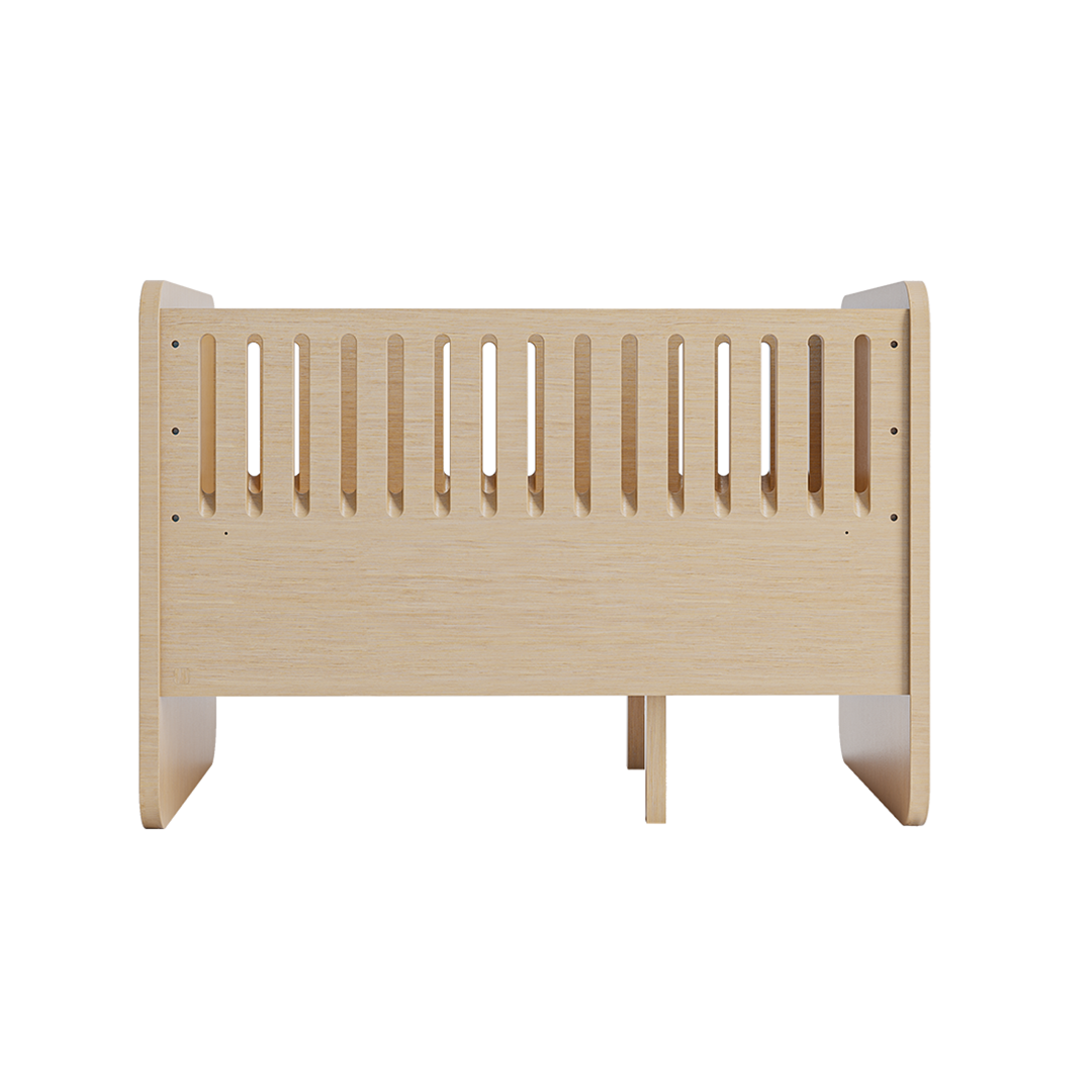 A light natural wood baby crib guard with vertical slats, shown from the front on a solid white background.