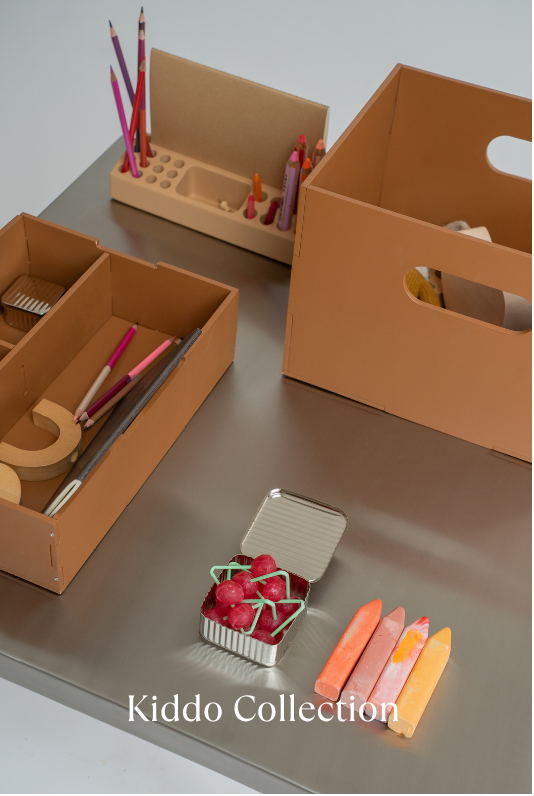 Kiddo Collection with brown storage boxes and stationery items on a metallic surface