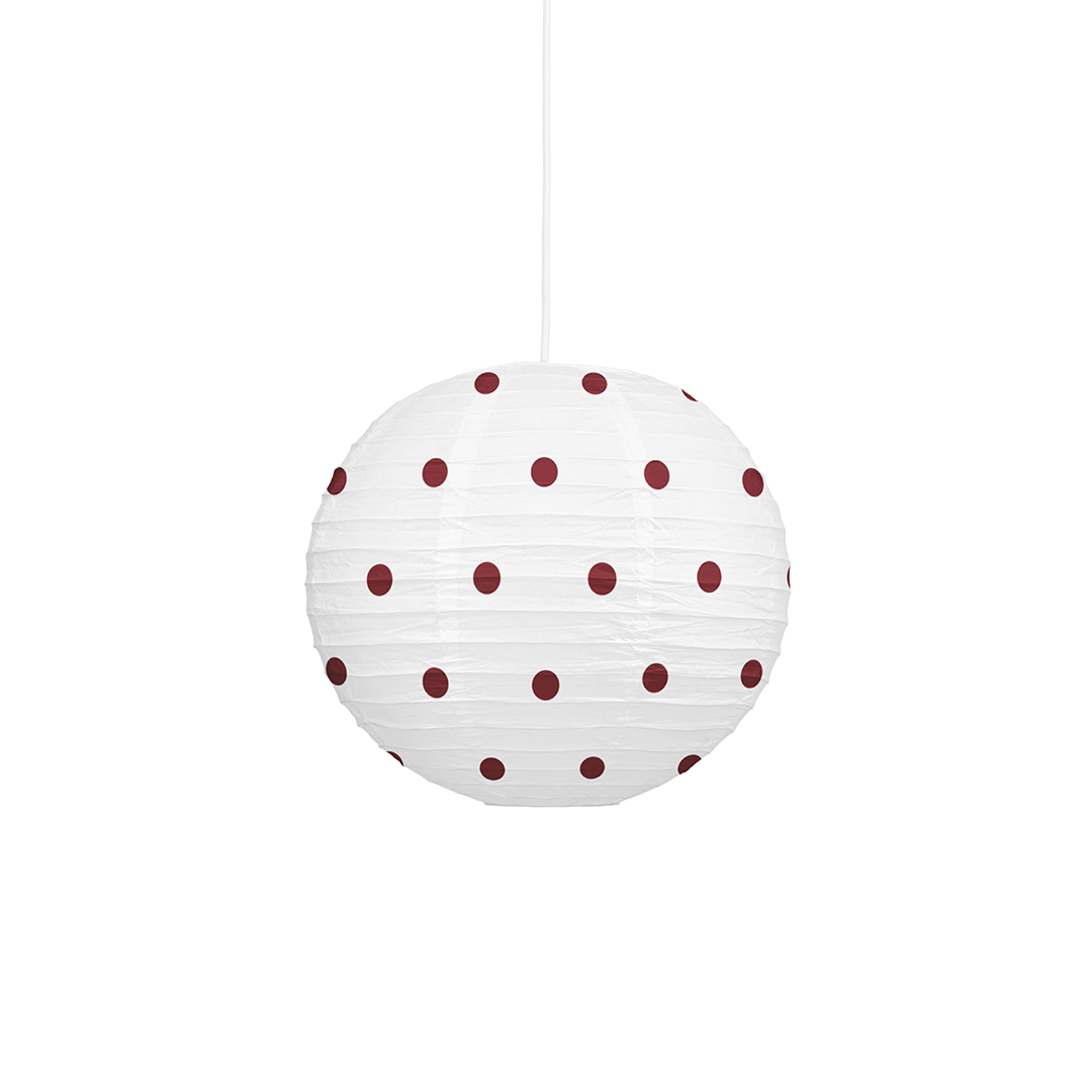 A white paper lantern pendant light with dark red polka dots, suspended by a thin white cord against a solid white background.