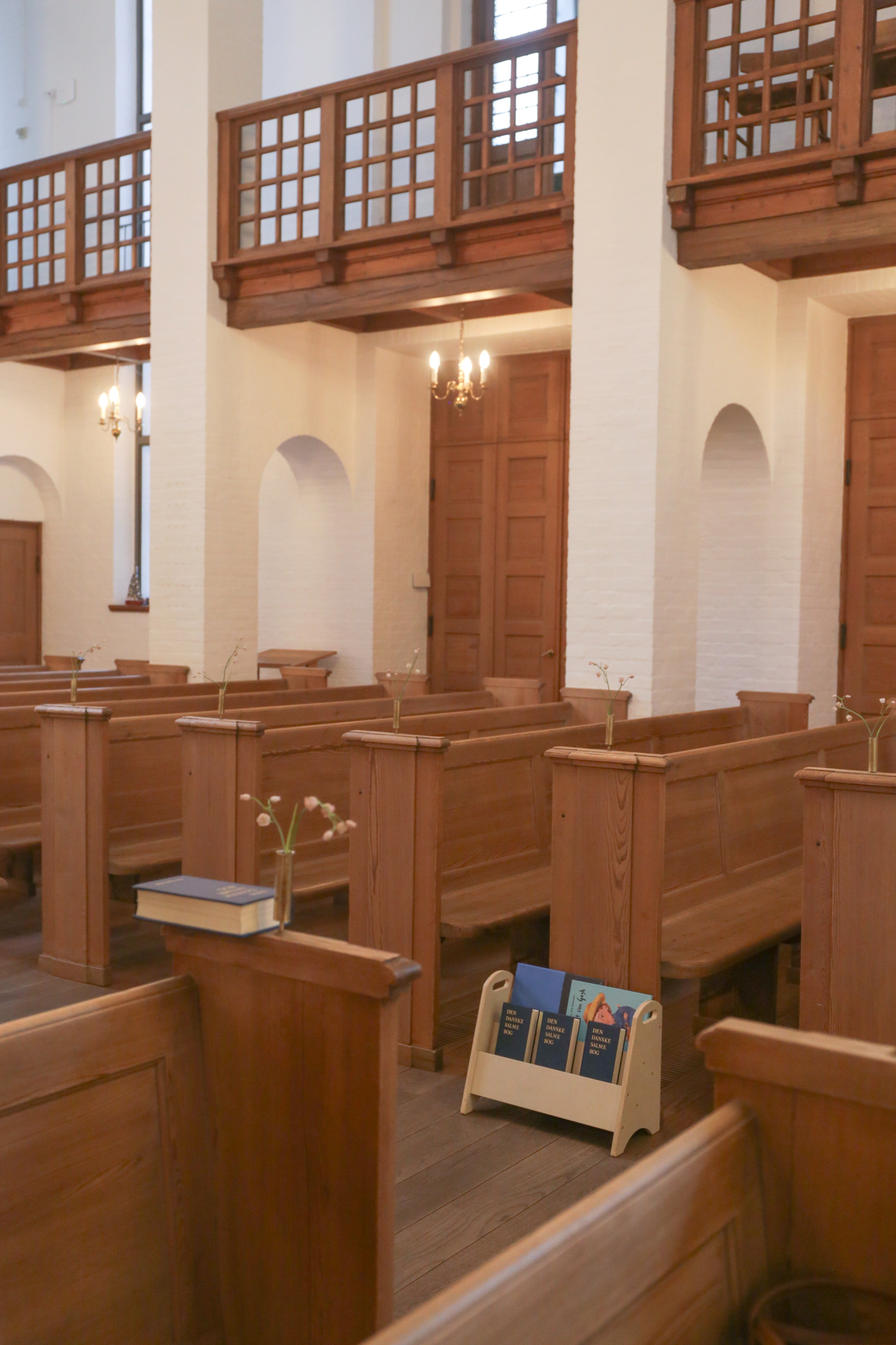 Interior of a church with wooden pews and a chandelier.
