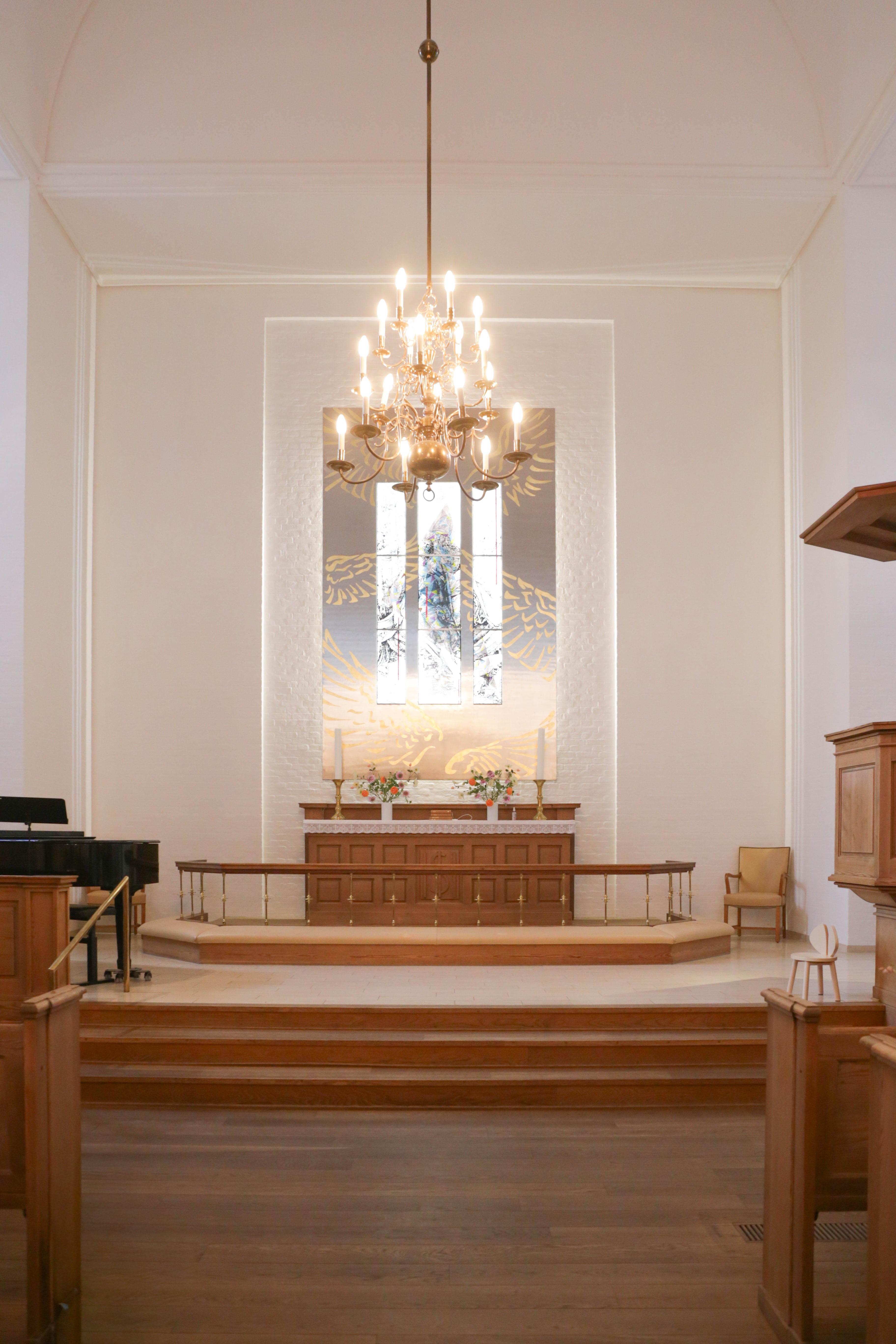 Interior of a church with a chandelier, pulpit, and pews.