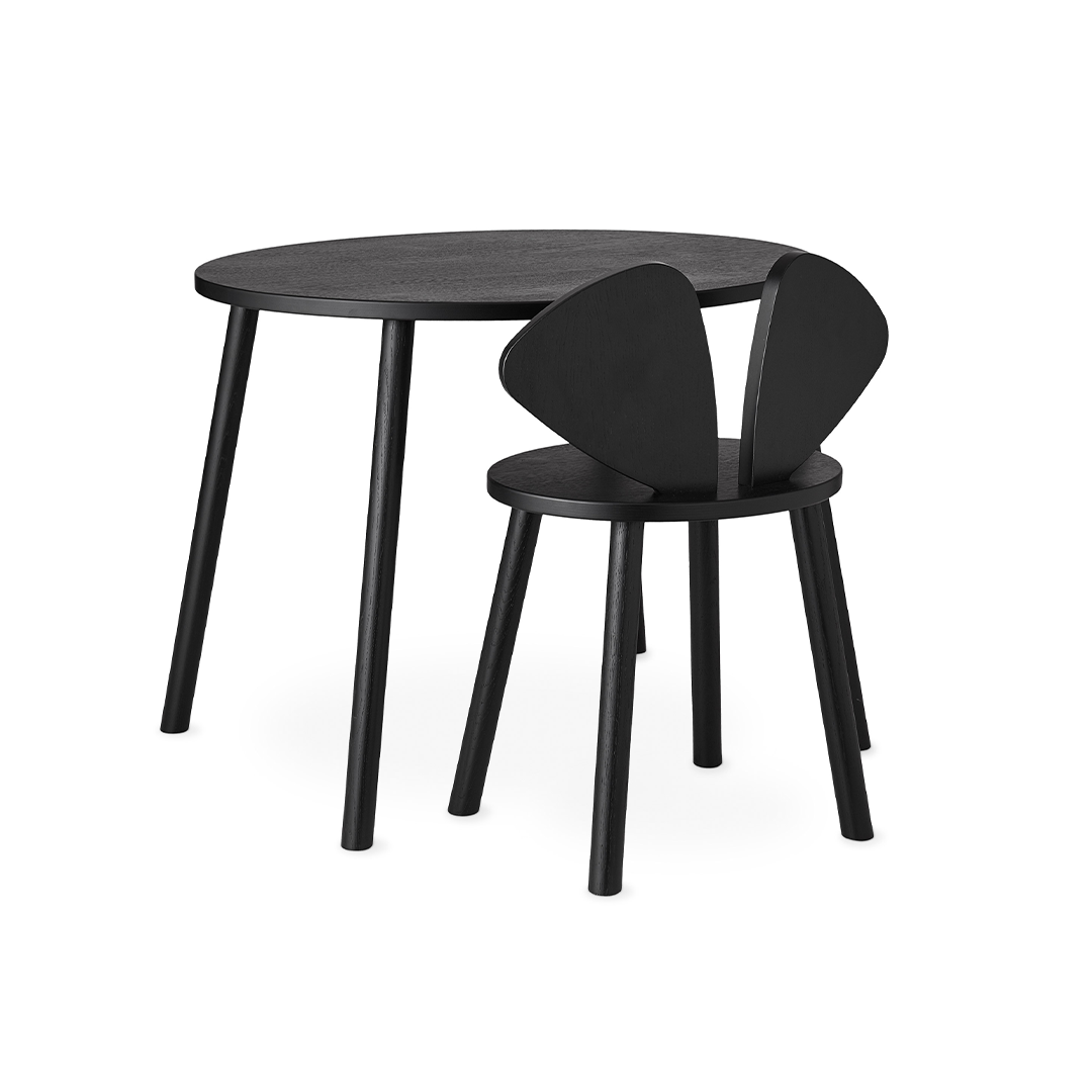 A minimalist black children's table and chair set on a clean white background. The round table has four slim legs, and the matching chair features a unique wing-like backrest.
