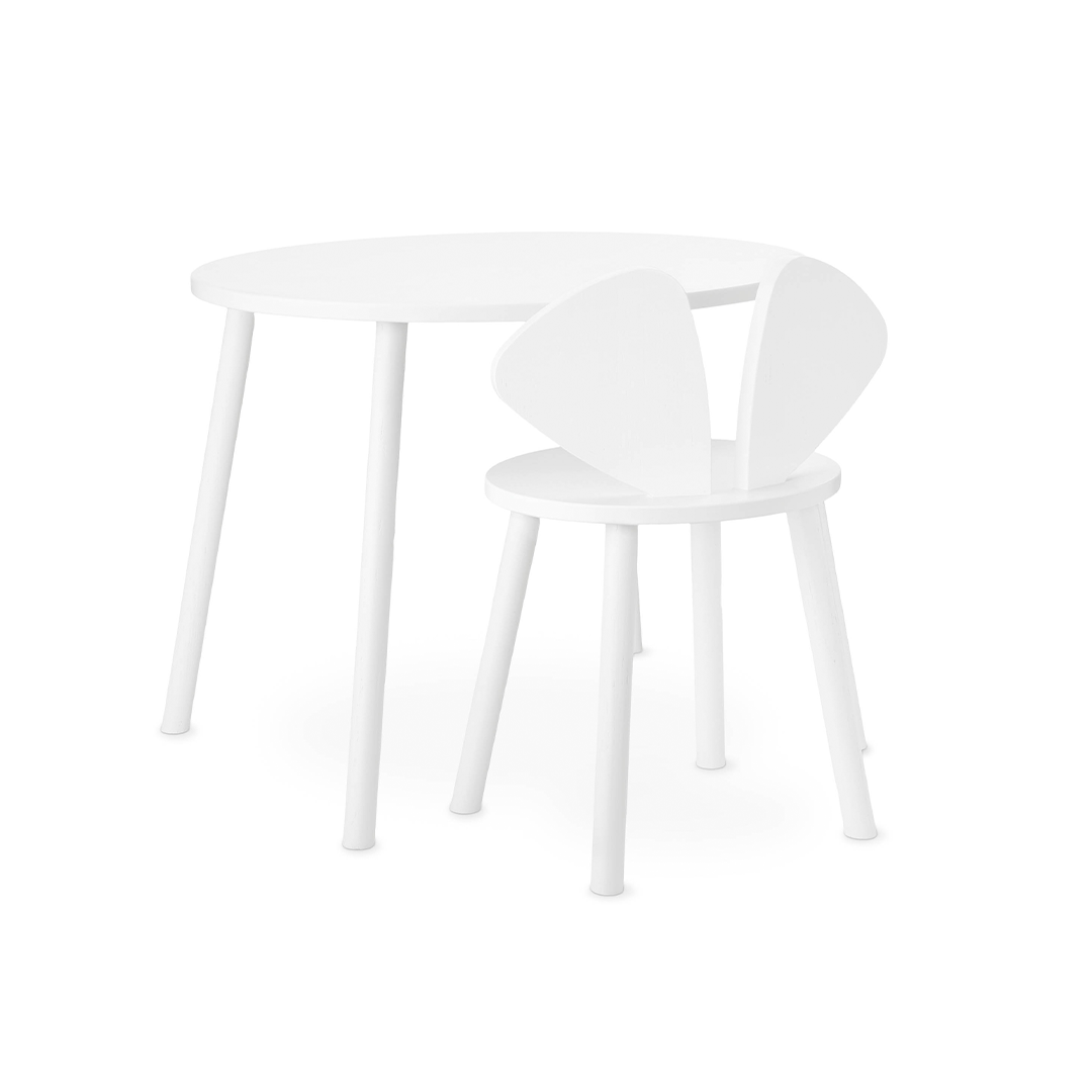 A minimalist white children's table and chair set on a seamless white background. The round table has slim tapered legs, and the matching chair features a unique winged or bunny-ear backrest design.