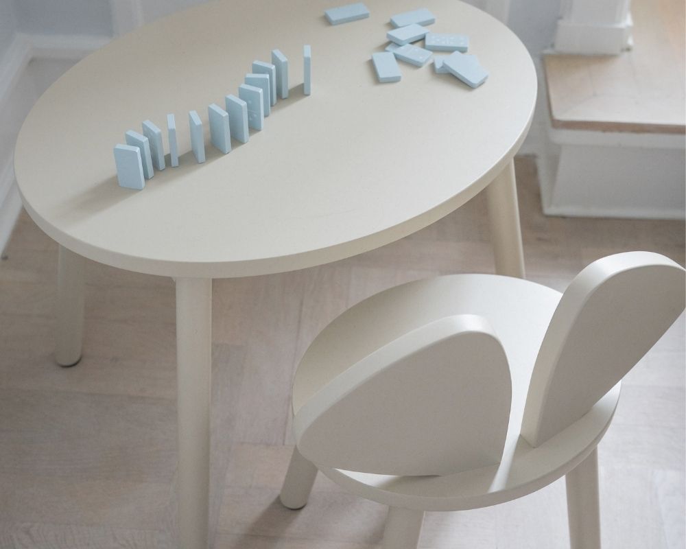 Light wooden table with blue geometric blocks on a white floor.