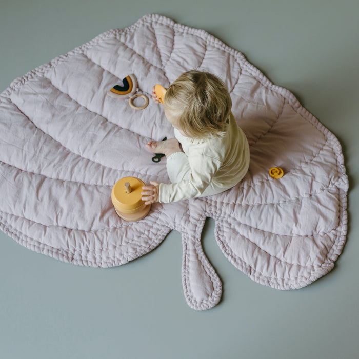 Little girl playing with toys on Leaf blanket