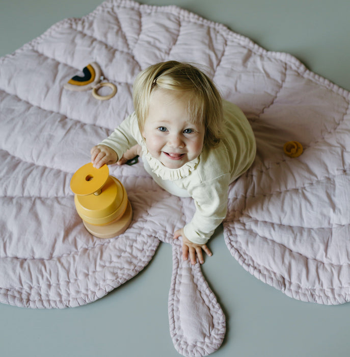 Happy little girl playing on nofred organic leaf blanket