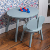 Children's table and chair set with colorful blocks on a wooden floor.