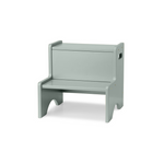 A light sage green wooden step stool with a built-in storage box on the backrest, shown on a plain white background.