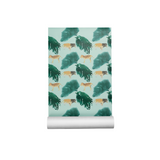 A roll of wallpaper with a repeating pattern of watercolor-style tigers and dark green trees on a pale mint background, shown partially unrolled against a plain white studio background.