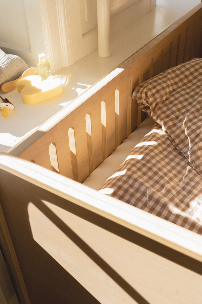 Sunlight filtering through a window onto a bed with checkered bedding.