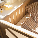 Wooden crib with checkered blanket and toys in a softly lit room