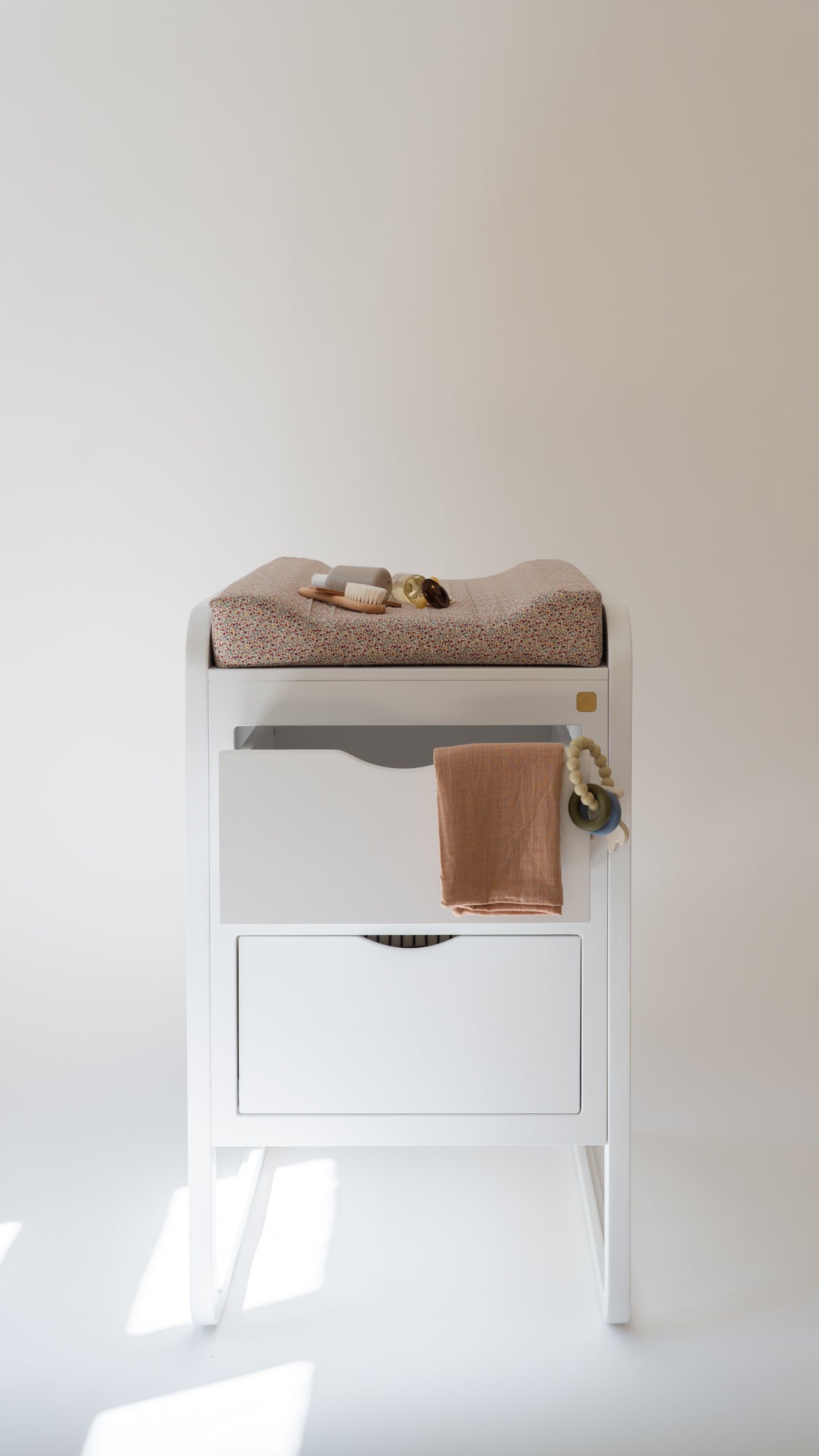 White changing table with brown towels on a plain white background