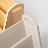 Close-up detail of a modern storage unit or bookshelf, showing a light beige plastic tiered section with a handle cutout next to a natural wood slatted section on a light gray background.