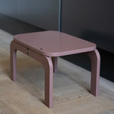 Pink children's table on a wooden floor with a neutral wall background
