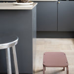 Modern kitchen with a gray island and pink stool