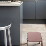 Modern kitchen with a gray island and pink stool