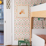 Children's room with floral wallpaper, bunk bed, and green stool.