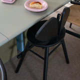 A black wooden chair standing next to the table in the dining room