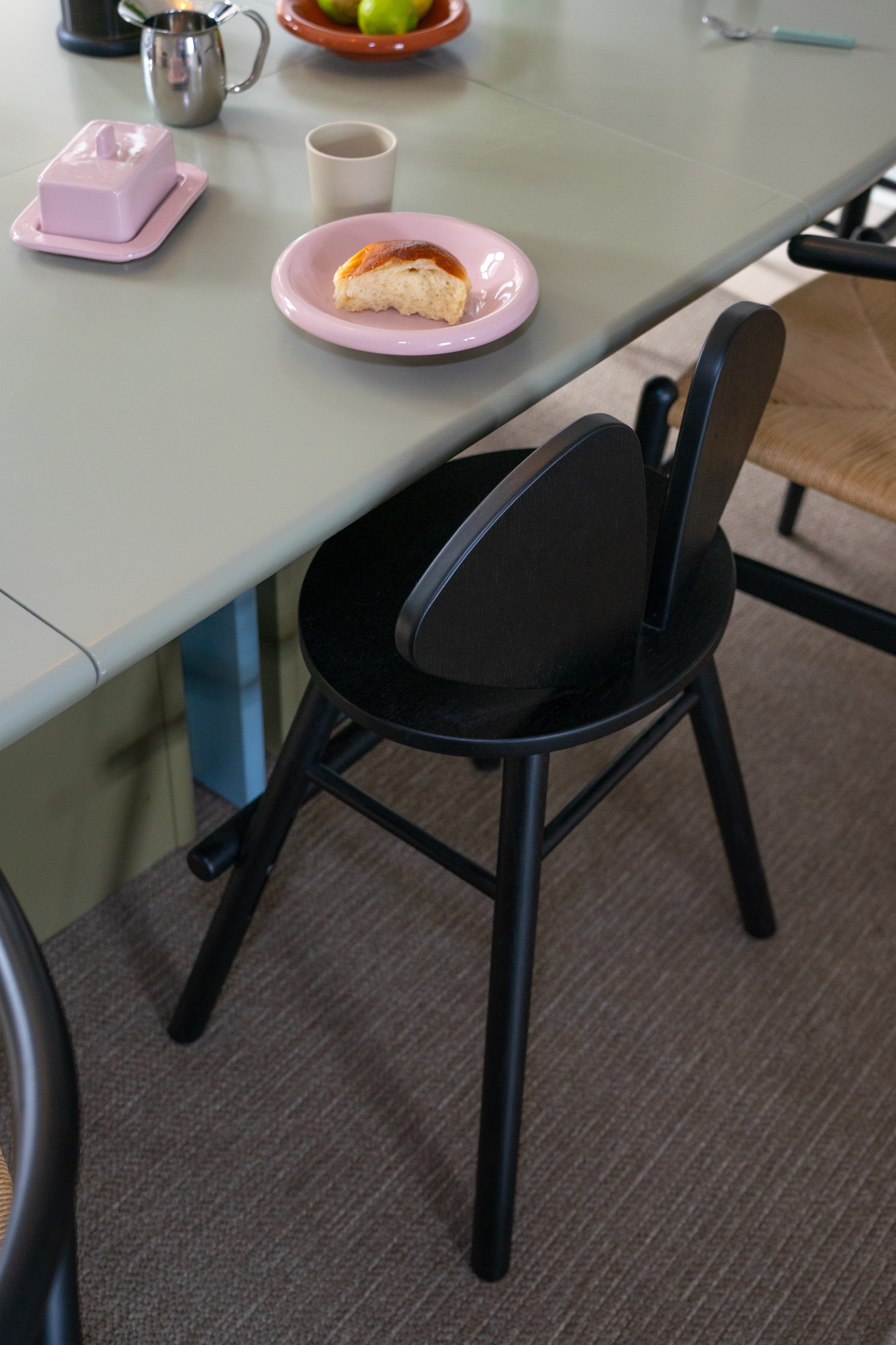 A black wooden chair standing next to the table in the dining room