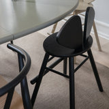 Black chairs around a round table in a room with beige carpet.