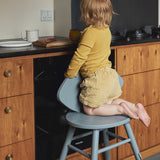 Child sitting on a high chair in a kitchen