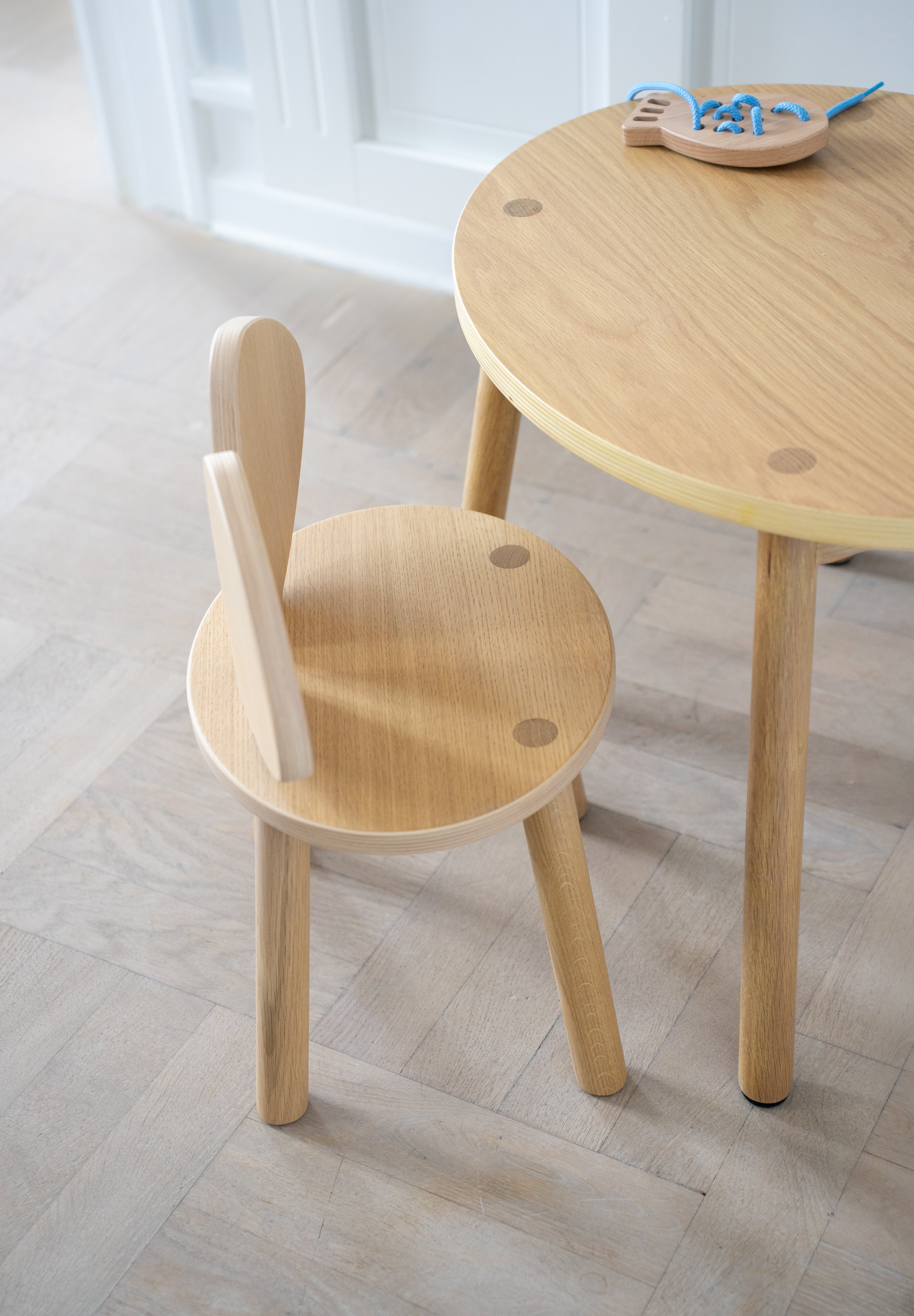 Wooden children's table and chair set on a light wooden floor.