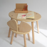 Wooden children's table and chair set with art supplies on a white background