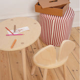 Children's wooden table and chair set with art supplies on a wooden floor.