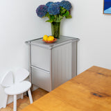 A wooden white chair standing next to a wall in the dining room