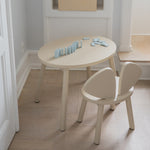 Children's table and chair set with toy blocks on a wooden floor.