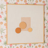 Decorative wall art with geometric shapes on a floral wallpaper background