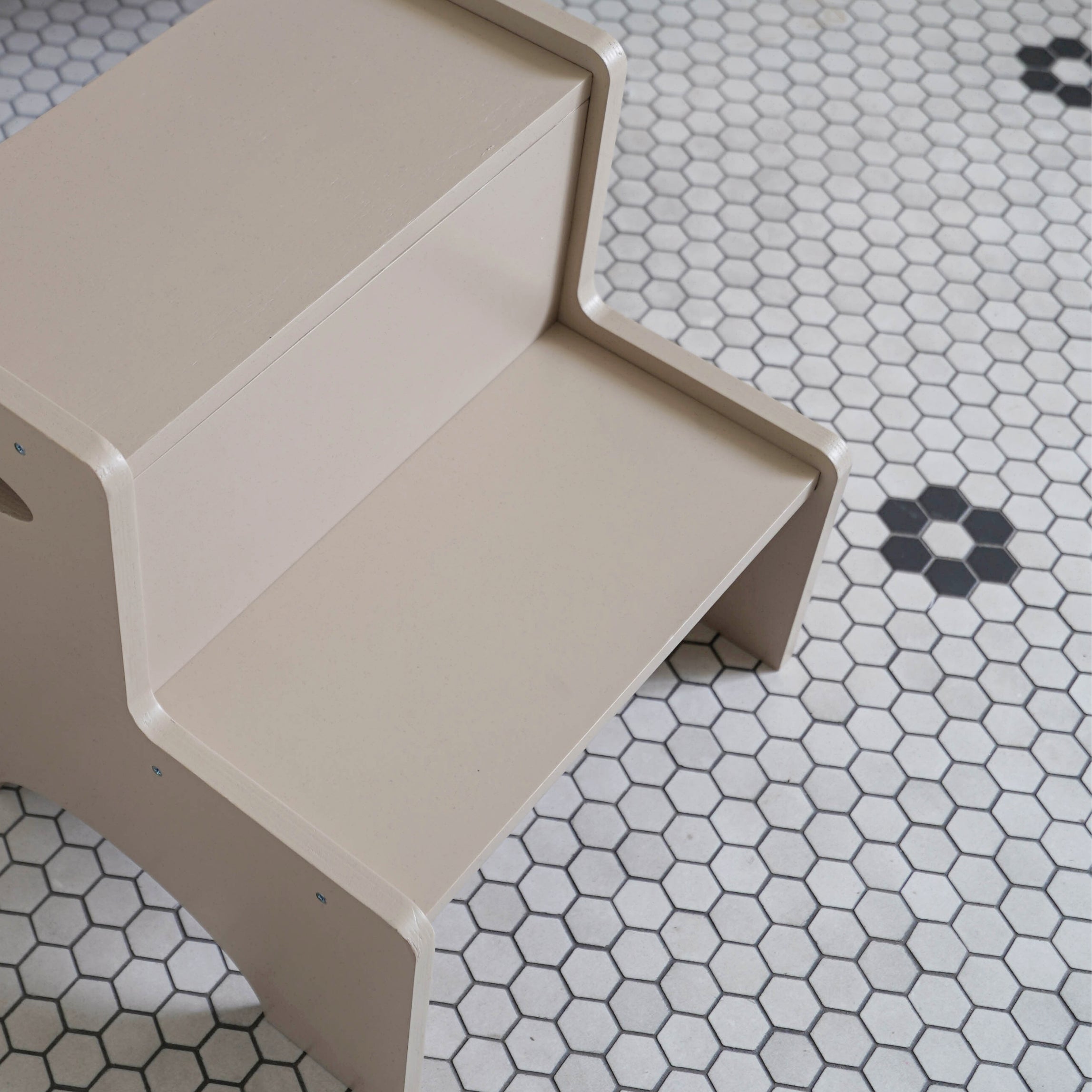 Beige step stool on a tiled floor