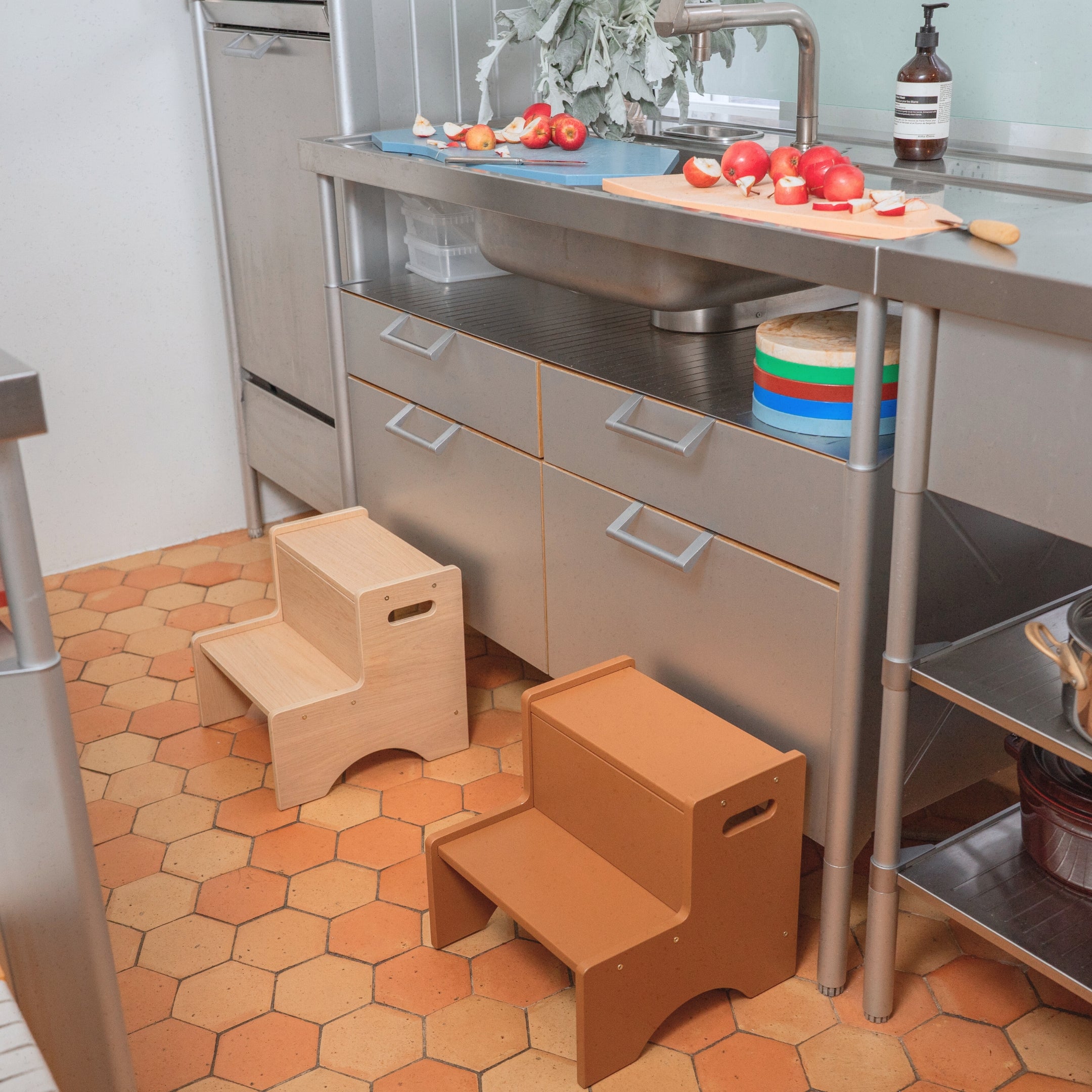 Wooden step stool in a kitchen setting with hexagonal tiled floor