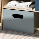 Gray storage box with a handle on a wooden surface with books and records.
