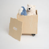 Birch Nofred Cube Storage on black wheels, holding soft toys with its removable lid leaning against the front.