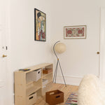 Small room with wooden floor, bookshelf, and wall art