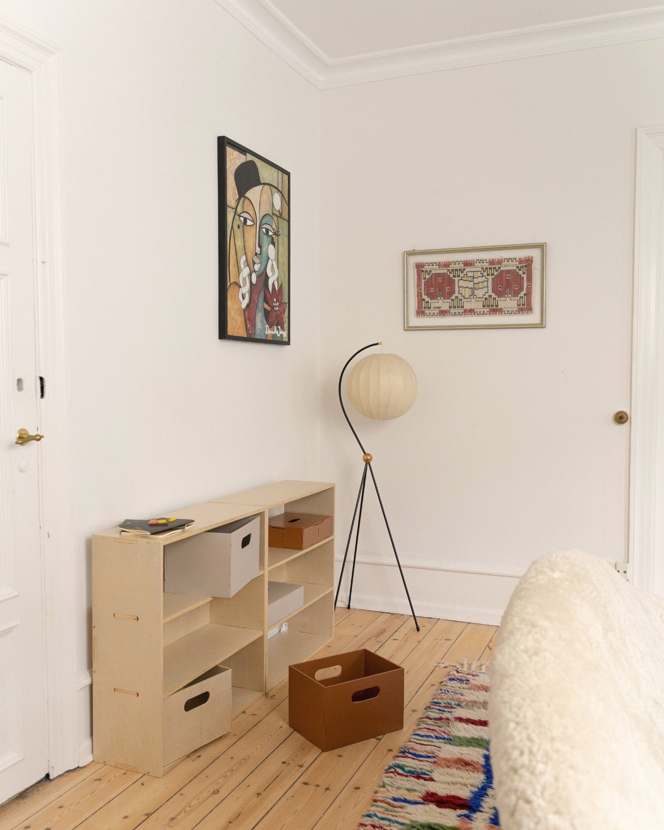 Small room with wooden floor, bookshelf, and wall art