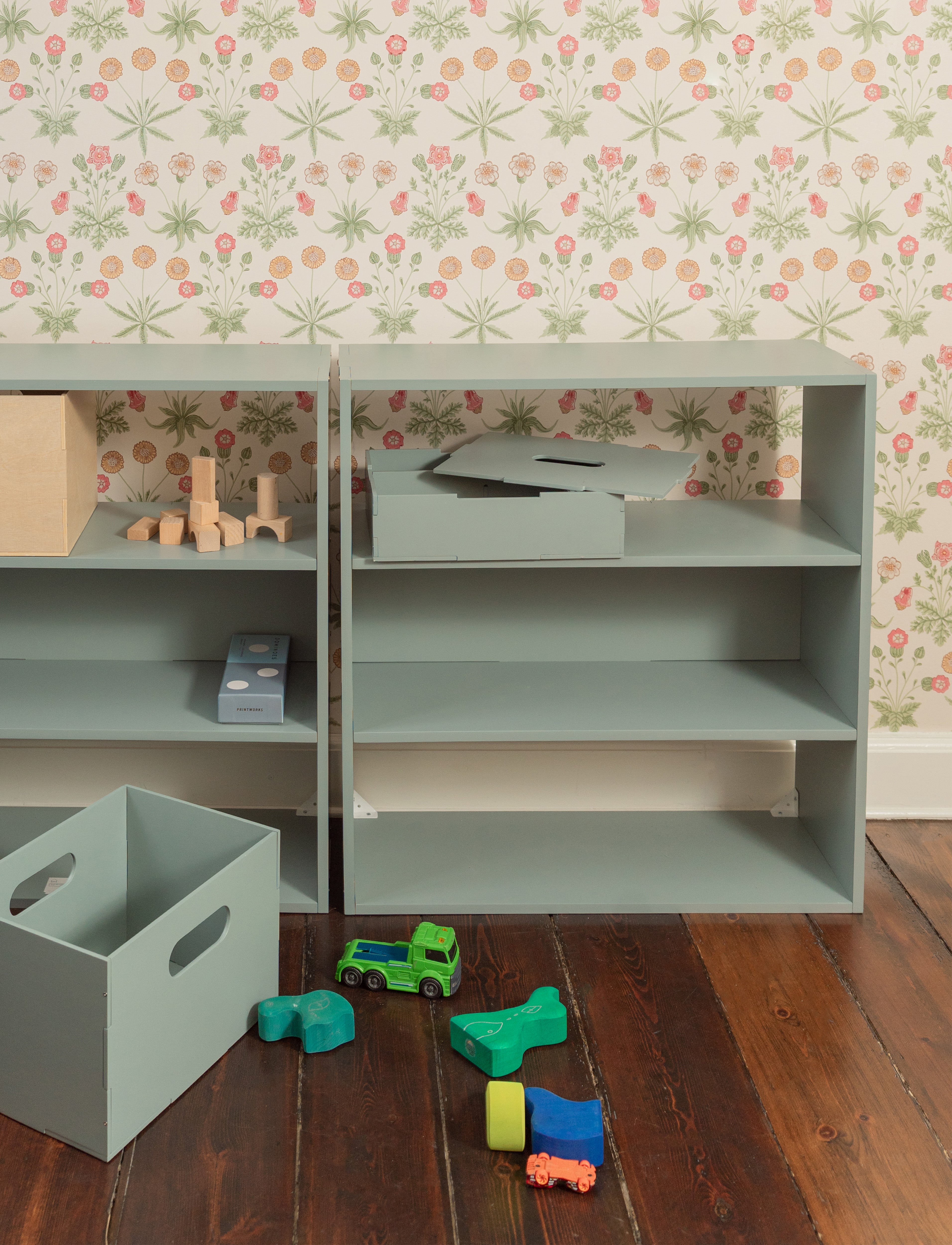 A shelving system in the kids room with the toys n front of it