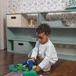 A shelving system in the kids room with a kid playing in front of it