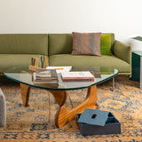 Wooden shelf with a blue box, white shoes, and a toy car against a gray wall.