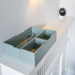 Light blue storage box with compartments on a white staircase
