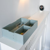 Light blue storage box with compartments on a white staircase