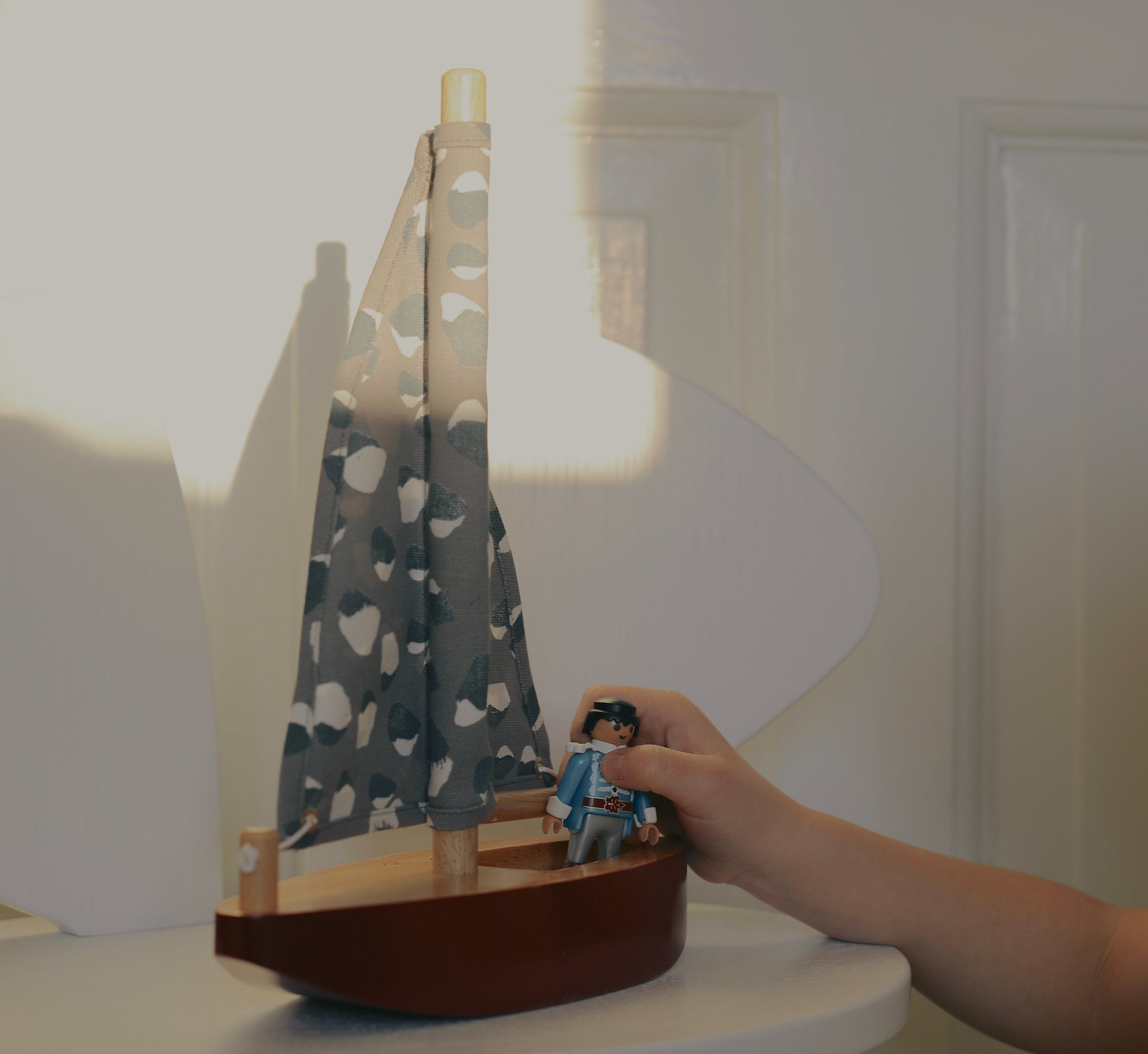 Child playing with Nofred Burgundy Toy Sailing Boat