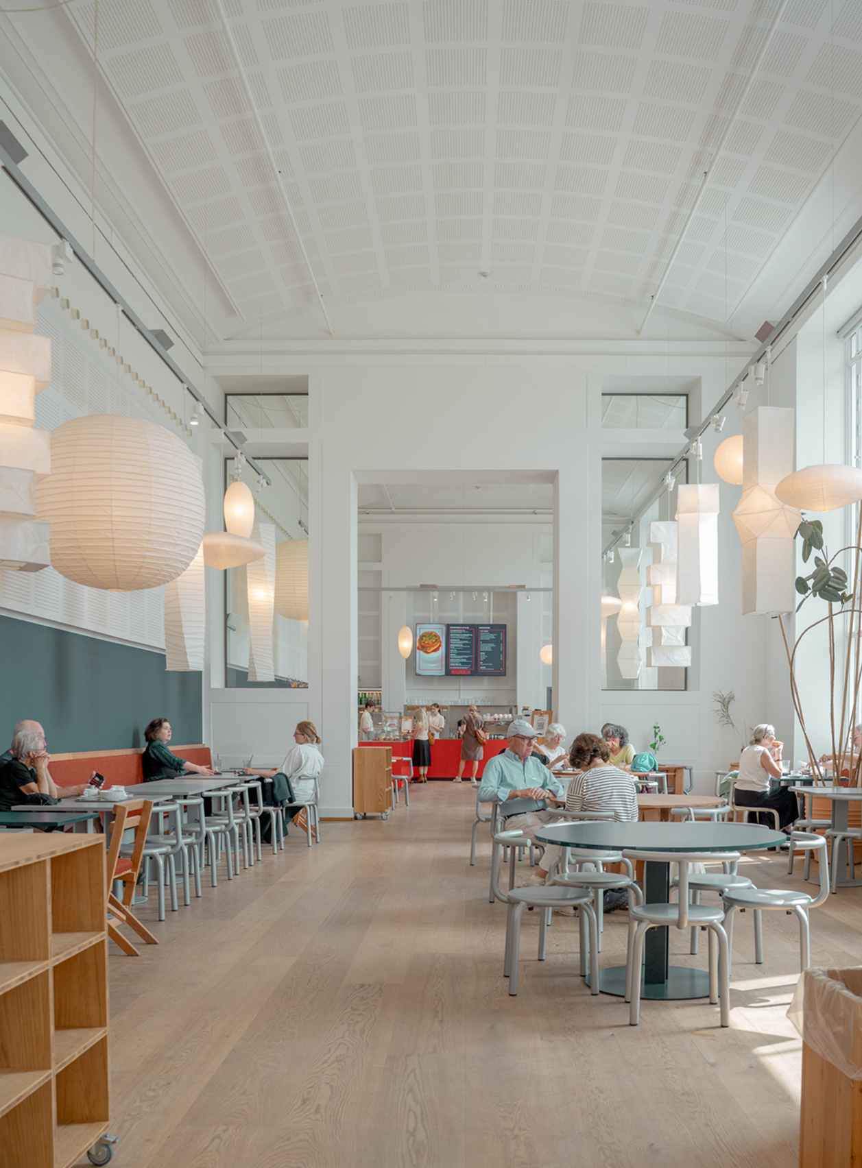 Modern cafe interior with tables, chairs, and people.