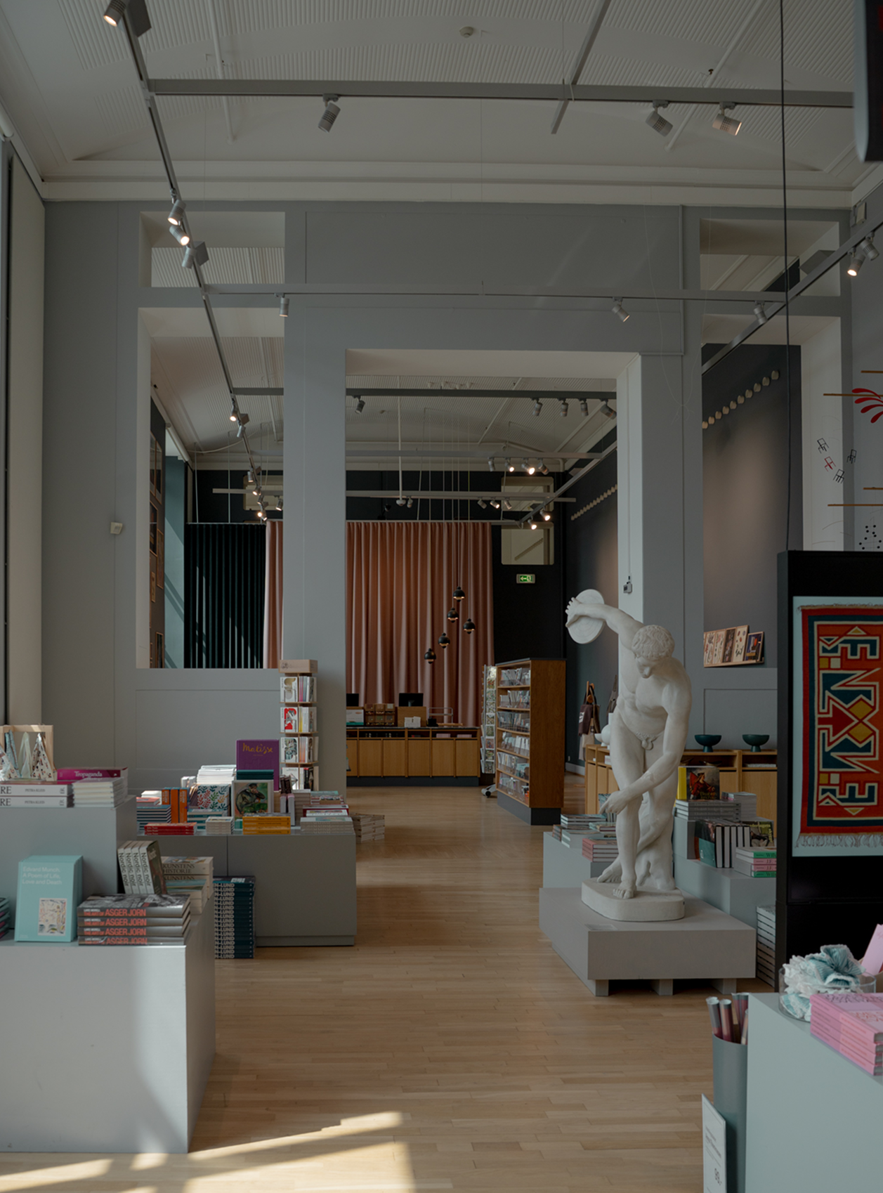 Interior of a modern bookstore with a statue and bookshelves.